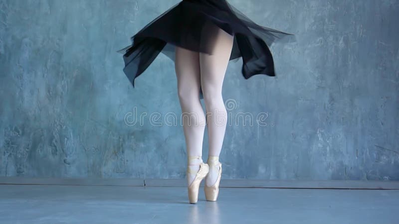 La ragazza nei pointes balla su un fondo grigio in una scuola di balletto La bella ballerina balla alla scuola di balletto E