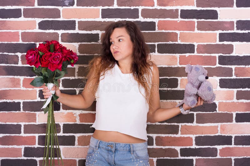 La ragazza non può decidere quale presente è migliore fotografia stock La ragazza non può decidere quale presente è migliore fotografia stock