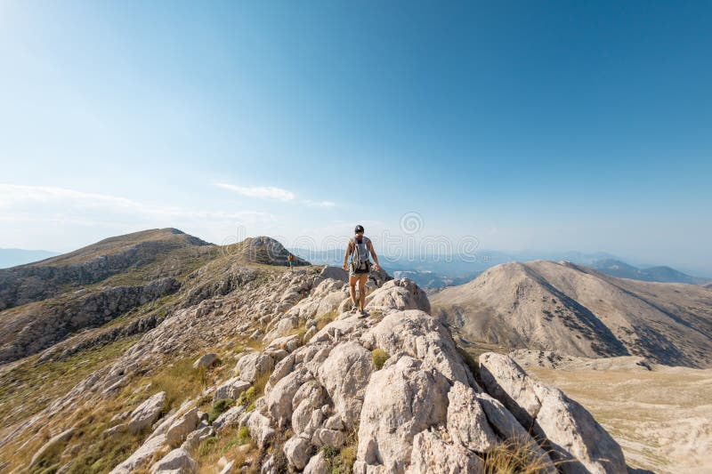 La ragazza sta camminando lungo la cresta della montagna immagine stock libera da diritti