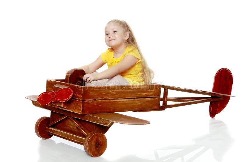 La ragazza sta guidando un aereo del giocattolo immagine stock libera da diritti La ragazza sta guidando un aereo del giocattolo immagine stock libera da diritti