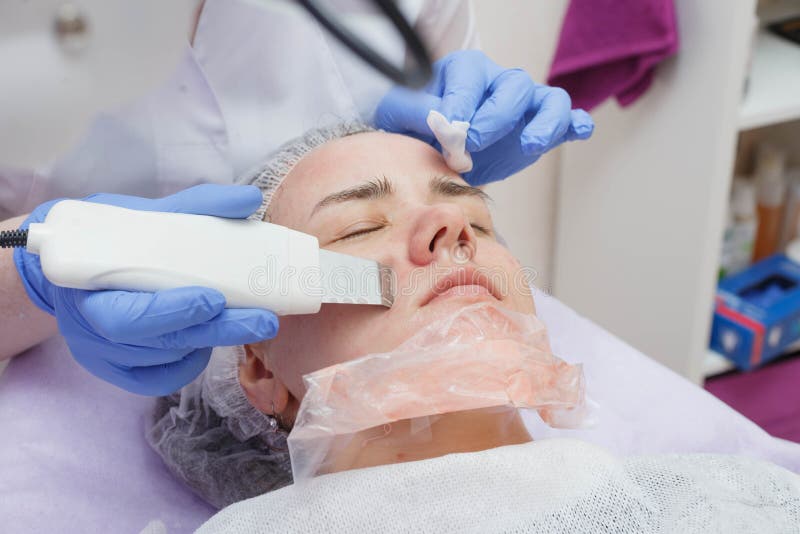 La ragazza è fornita di un servizio di pulizia della pelle di ultrasuono nel salone di bellezza immagine stock La ragazza è fornita di un servizio di pulizia della pelle di ultrasuono nel salone di bellezza immagine stock