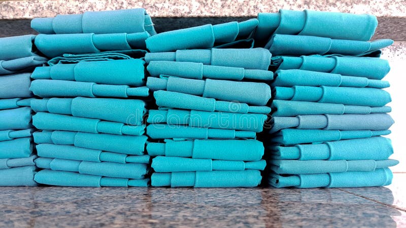 La rangée du tissu vert de napery a arrangé sur la table de marbre photo libre de droits La rangée du tissu vert de napery a arrangé sur la table de marbre photo libre de droits