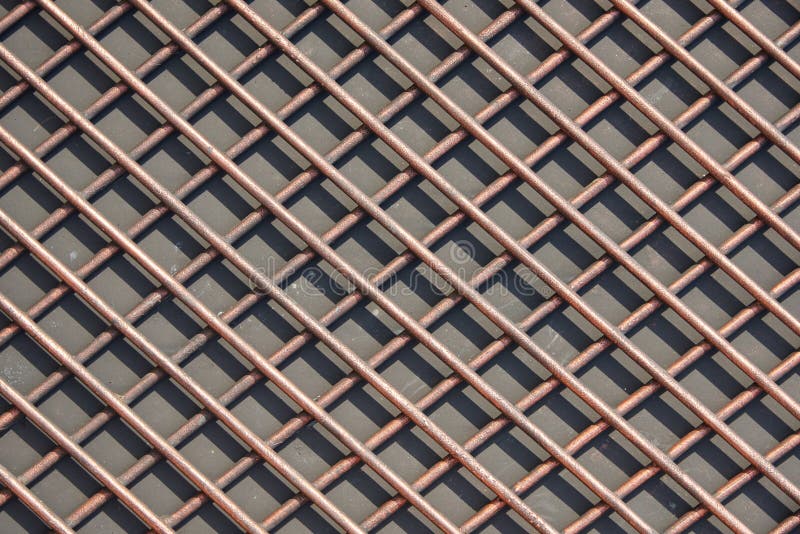 The grid of thick rods and its shade from the sun. Rods made of nonferrous metal. Texture, background. The grid of thick rods and its shade from the sun. Rods made of nonferrous metal. Texture, background