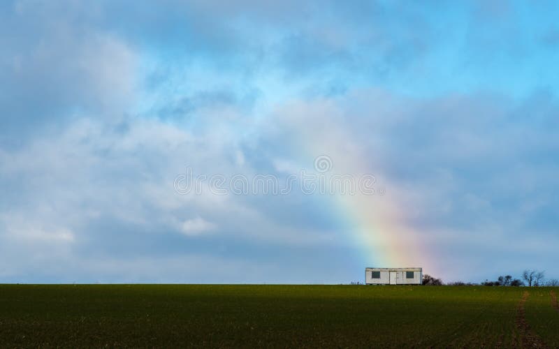 La remorque avec un arc-en-ciel sur un champ images stock La remorque avec un arc-en-ciel sur un champ images stock