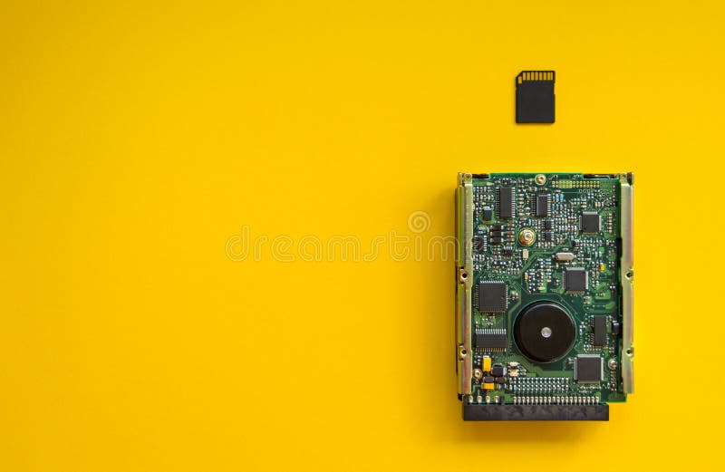 La revolución de los dispositivos de memoria de la tecnología en un fondo amarillo, concepto La tarjeta del disco duro y de memor fotografía de archivo La revolución de los dispositivos de memoria de la tecnología en un fondo amarillo, concepto La tarjeta del disco duro y de memor fotografía de archivo