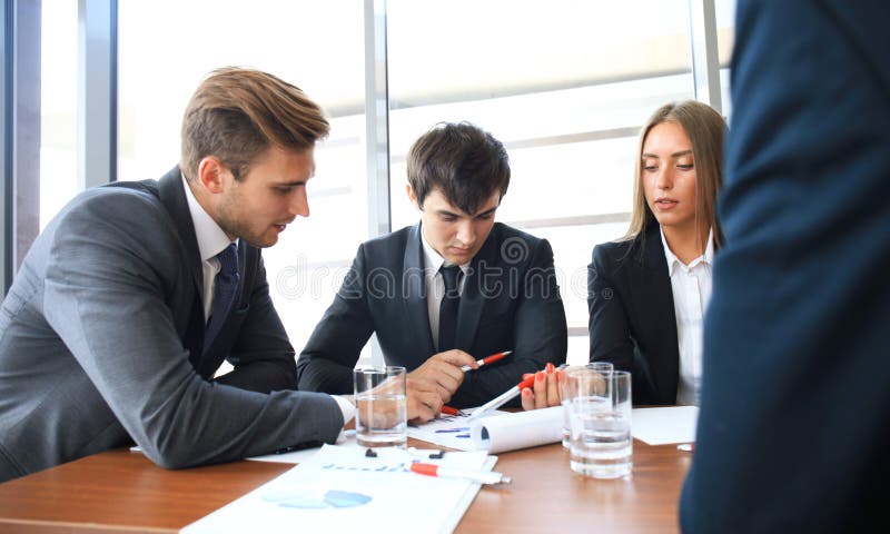 La riunione d'affari in un ufficio, le persone di affari sta discutendo un documento fotografie stock La riunione d'affari in un ufficio, le persone di affari sta discutendo un documento fotografie stock