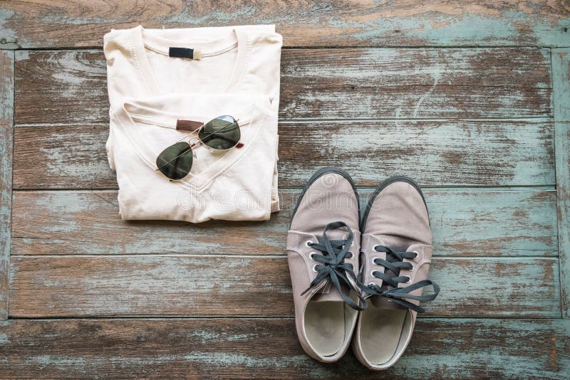 La ropa, las gafas de sol, y los zapatos del hombre ponen en el fondo de madera del vintage, fotografía de archivo La ropa, las gafas de sol, y los zapatos del hombre ponen en el fondo de madera del vintage, fotografía de archivo