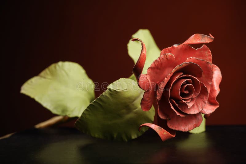 La rosa con una floración roja y un tallo verde hechos del metal imágenes de archivo libres de regalías La rosa con una floración roja y un tallo verde hechos del metal imágenes de archivo libres de regalías