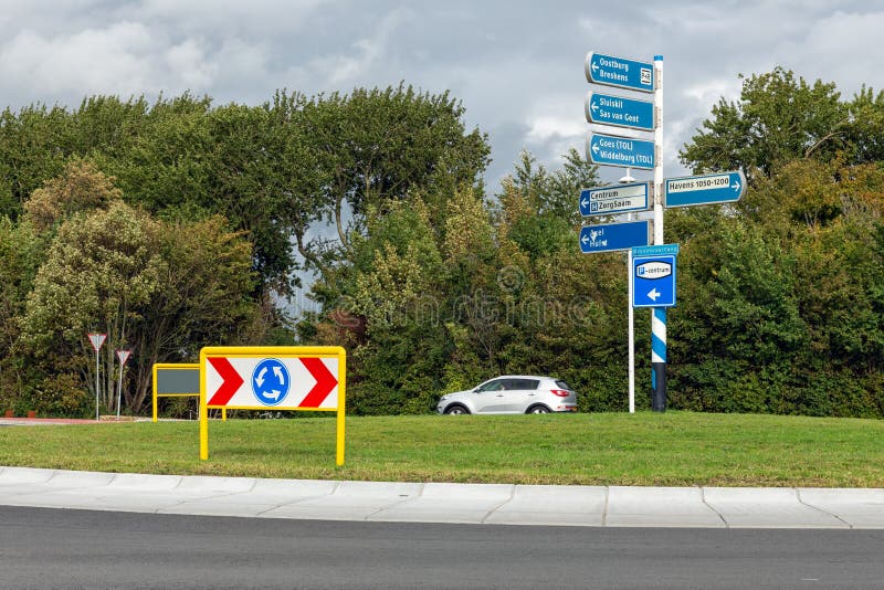 La rotatoria con segnaletica stradale vicino alla città olandese Terneuzen fotografia stock La rotatoria con segnaletica stradale vicino alla città olandese Terneuzen fotografia stock