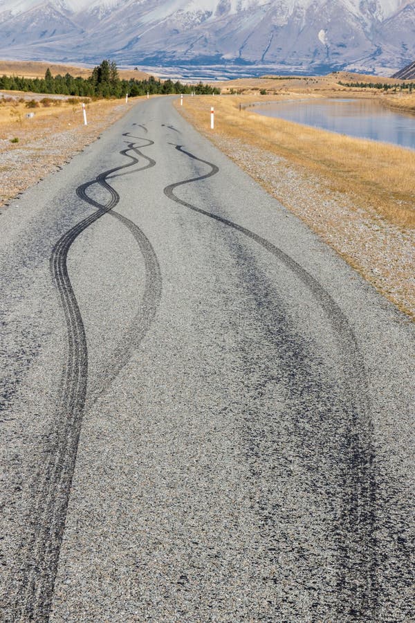 La route goudronnée avec les marques de dérapage en caoutchouc noires de pneu image libre de droits La route goudronnée avec les marques de dérapage en caoutchouc noires de pneu image libre de droits