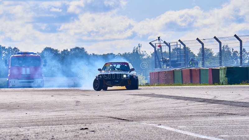 Russia Ryazan International Track Atron September 2020. A sports car in a controlled skid on the track. Smoke billows from under the wheels. Russia Ryazan International Track Atron September 2020. A sports car in a controlled skid on the track. Smoke billows from under the wheels