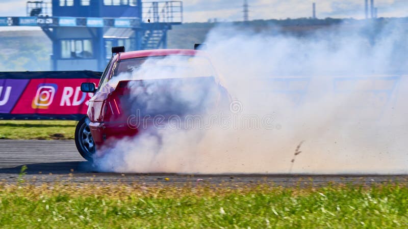 Russia Ryazan International Track Atron September 2020. A sports car in a controlled skid on the track. Smoke billows from under the wheels. Russia Ryazan International Track Atron September 2020. A sports car in a controlled skid on the track. Smoke billows from under the wheels