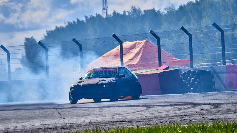 Russia Ryazan International Track Atron September 2020. A sports car in a controlled skid on the track. Smoke billows from under the wheels. Russia Ryazan International Track Atron September 2020. A sports car in a controlled skid on the track. Smoke billows from under the wheels