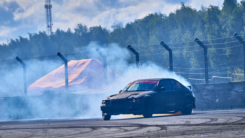 Russia Ryazan International Track Atron September 2020. A sports car in a controlled skid on the track. Smoke billows from under the wheels. Russia Ryazan International Track Atron September 2020. A sports car in a controlled skid on the track. Smoke billows from under the wheels