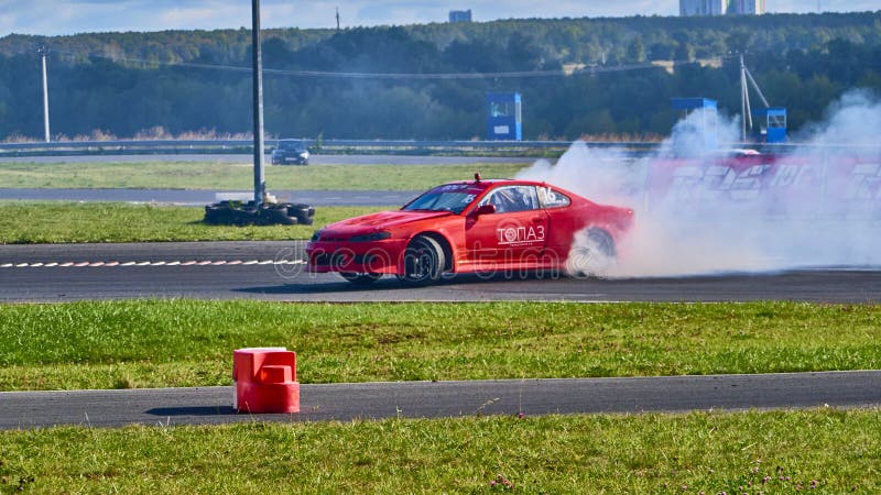 Russia Ryazan International Track Atron September 2020. A sports car in a controlled skid on the track. Smoke billows from under the wheels. Russia Ryazan International Track Atron September 2020. A sports car in a controlled skid on the track. Smoke billows from under the wheels