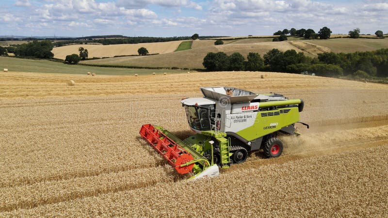 Claas Combine La Moissonneuse Recoltant Un Champ Tout En Vidant Son Grain Dans Un Tracteur Voisin. Image editorial Image du industriel zone 262710140