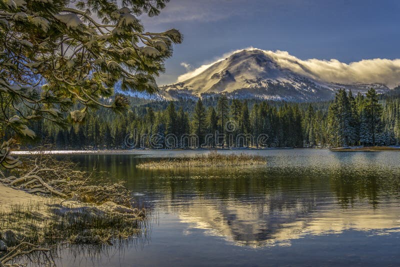 La réflexion de la neige a couvert la crête de Lassen et la branche de pin, parc national volcanique de lac Manzanita, Lassen photographie stock La réflexion de la neige a couvert la crête de Lassen et la branche de pin, parc national volcanique de lac Manzanita, Lassen photographie stock