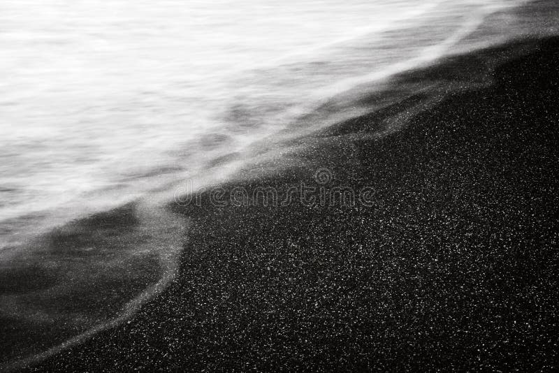 La sabbia ed il mare scuri ondeggiano il fondo bianco nero strutturale dell'estratto lungo dell'esposizione immagini stock libere da diritti La sabbia ed il mare scuri ondeggiano il fondo bianco nero strutturale dell'estratto lungo dell'esposizione immagini stock libere da diritti