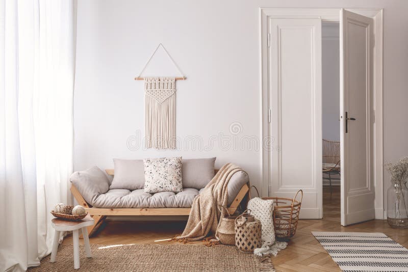 La sala de estar brillante interior con las cestas únicas, hechas a mano hizo de materiales naturales y de un sofá de madera acog imagen de archivo