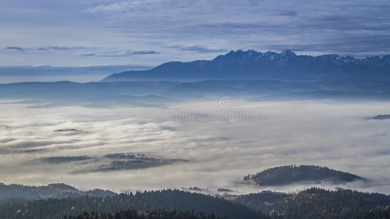 La salida del sol imponente con fluir se nubla en las montañas de Tatra, Polonia