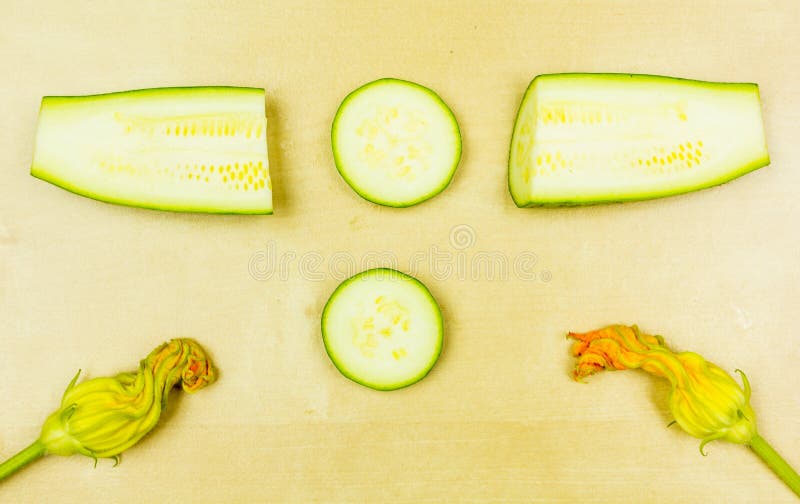 La section en coupe et longitudinale de la jeune courgette a présenté sur le conseil image stock La section en coupe et longitudinale de la jeune courgette a présenté sur le conseil image stock