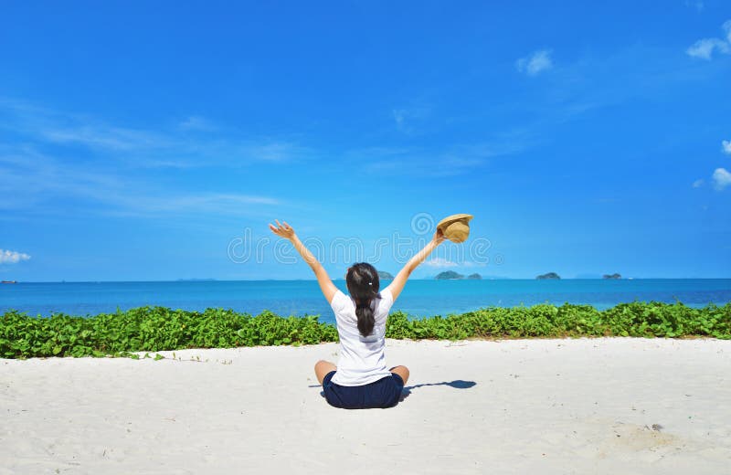 La seduta felice della donna gode della vita sulla spiaggia
