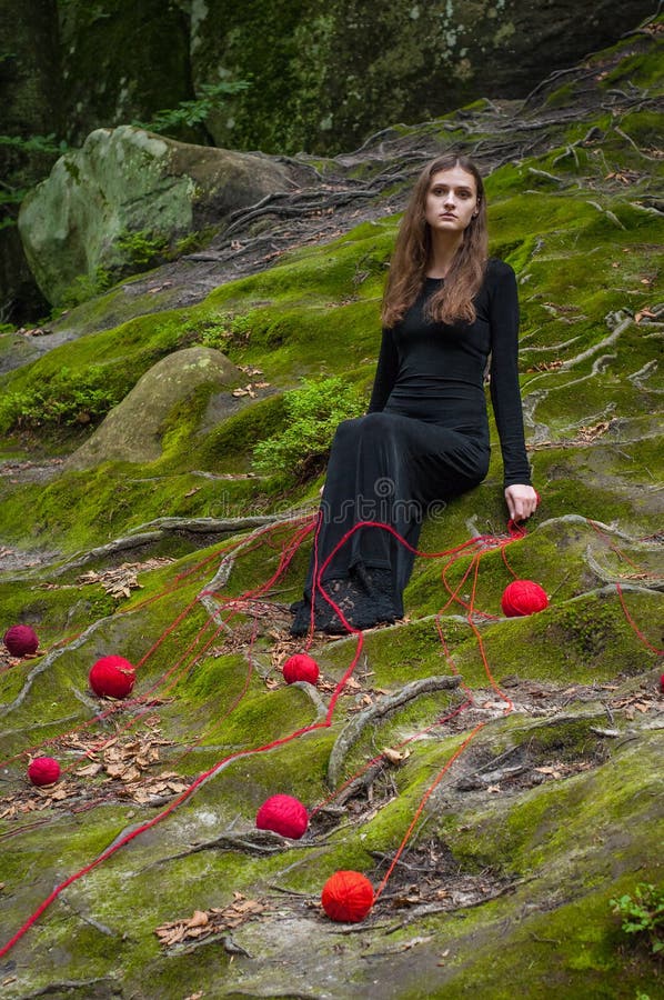 La seule belle fille s'assied sur la mousse verte dans une forêt de féerie photos libres de droits La seule belle fille s'assied sur la mousse verte dans une forêt de féerie photos libres de droits