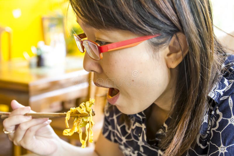 La señora asiática está comiendo comiendo los tallarines tailandeses del lanna. fotos de archivo libres de regalías La señora asiática está comiendo comiendo los tallarines tailandeses del lanna. fotos de archivo libres de regalías