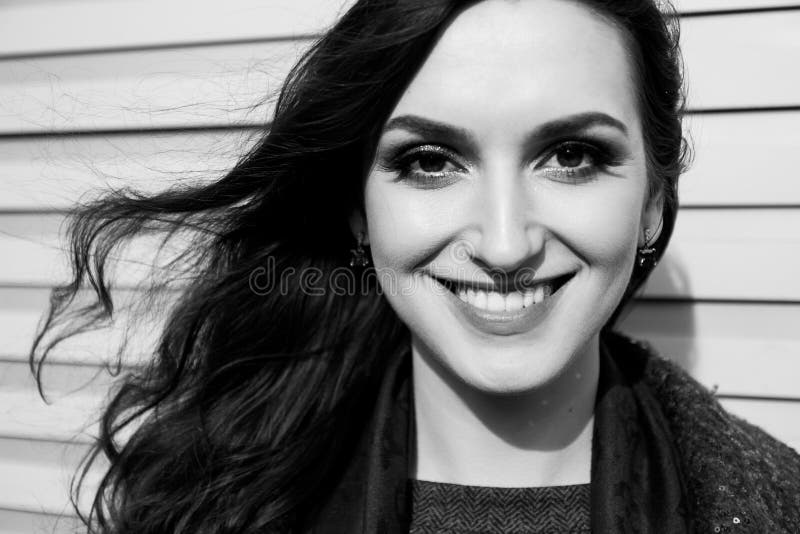 La señora con sonrisa encantadora está presentando en fondo de la pared Retrato urbano blanco y negro de la mujer joven con el pr fotos de archivo La señora con sonrisa encantadora está presentando en fondo de la pared Retrato urbano blanco y negro de la mujer joven con el pr fotos de archivo