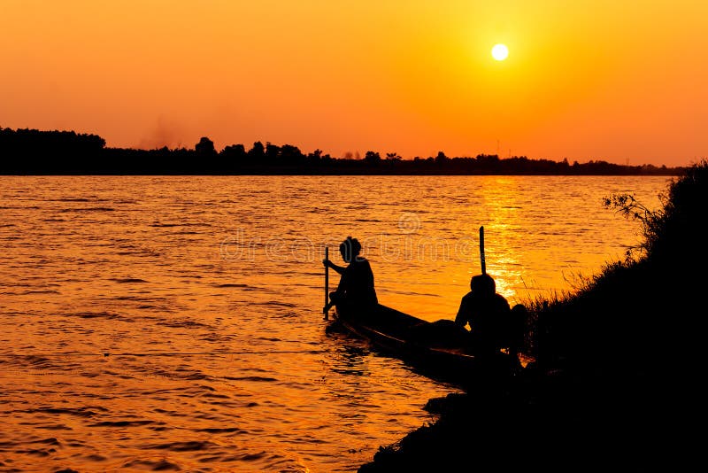 La siluetta dei pescatori pesca il pesce nel canale immagini stock libere da diritti La siluetta dei pescatori pesca il pesce nel canale immagini stock libere da diritti
