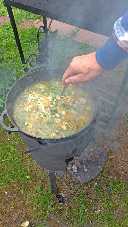 La sopa de pollo deliciosa se cocina en un fuego abierto en un molde negro fotografía de archivo libre de regalías La sopa de pollo deliciosa se cocina en un fuego abierto en un molde negro fotografía de archivo libre de regalías