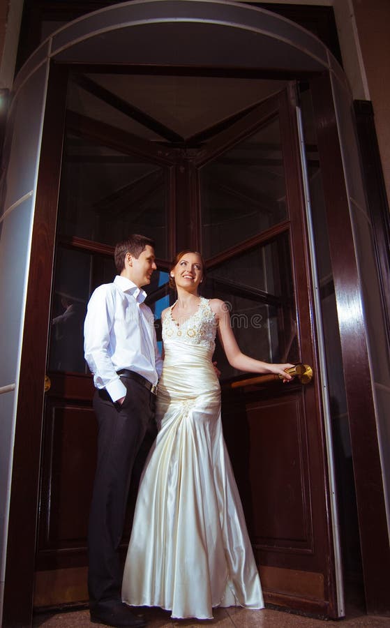 La sposa e lo sposo felici alle nozze camminano fotografia stock La sposa e lo sposo felici alle nozze camminano fotografia stock
