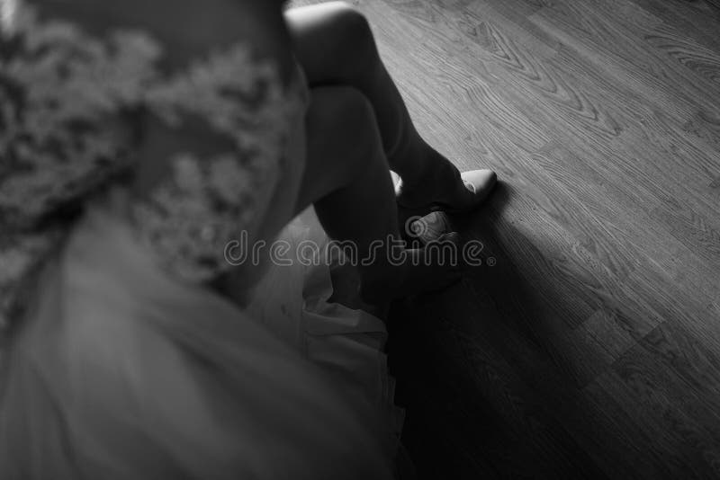 La sposa mette sopra le scarpe bianche sui piedi fotografie stock libere da diritti La sposa mette sopra le scarpe bianche sui piedi fotografie stock libere da diritti