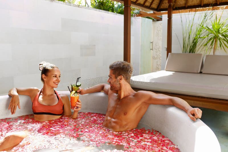 La stazione termale si distende Coppie nell'amore nelle bevande beventi del bagno del fiore immagine stock libera da diritti La stazione termale si distende Coppie nell'amore nelle bevande beventi del bagno del fiore immagine stock libera da diritti