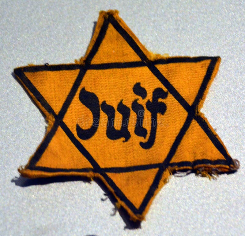 PARIS FRANCE 09 24 19: Patch Jewish star of David in concentration camps in Germany. The concept of the genocide of the Jews of memory of victims of the Holocaust. PARIS FRANCE 09 24 19: Patch Jewish star of David in concentration camps in Germany. The concept of the genocide of the Jews of memory of victims of the Holocaust.