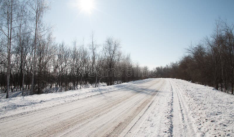 La strada dell'inverno entra in distanza dietro l'angolo. La strada dell'inverno va via dietro l'angolo, foresta dell'inverno, molte tracce dell'automobile