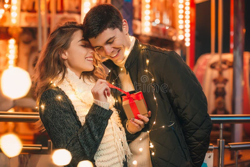 La surprise romantique pour Noël, femme reçoit un cadeau de son ami image libre de droits La surprise romantique pour Noël, femme reçoit un cadeau de son ami image libre de droits