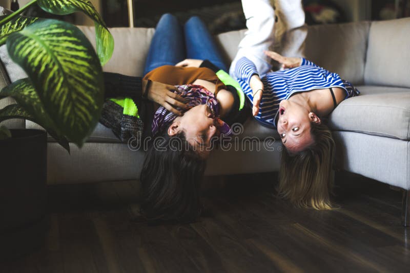 La séance de deux femmes sur le divan prennent un certain bon temps à la maison images stock La séance de deux femmes sur le divan prennent un certain bon temps à la maison images stock