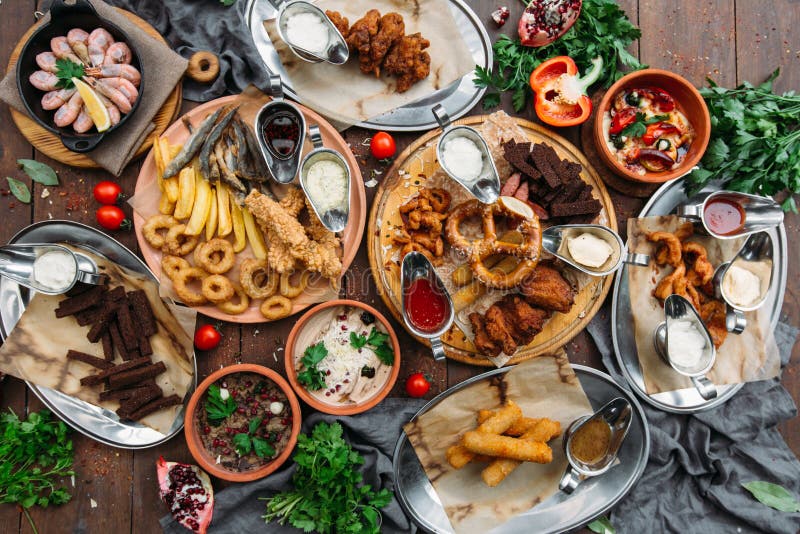 La tabla de cena con el camarón, pescado asó a la parrilla, ensalada, diversos bocados y cerveza de cerveza dorada, visión superi fotos de archivo libres de regalías La tabla de cena con el camarón, pescado asó a la parrilla, ensalada, diversos bocados y cerveza de cerveza dorada, visión superi fotos de archivo libres de regalías
