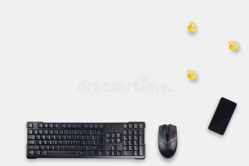 La table blanche avec le clavier, la souris, le smartphone et trois de noir d'ordinateur a chiffonné la couleur jaune de papier d photo libre de droits La table blanche avec le clavier, la souris, le smartphone et trois de noir d'ordinateur a chiffonné la couleur jaune de papier d photo libre de droits