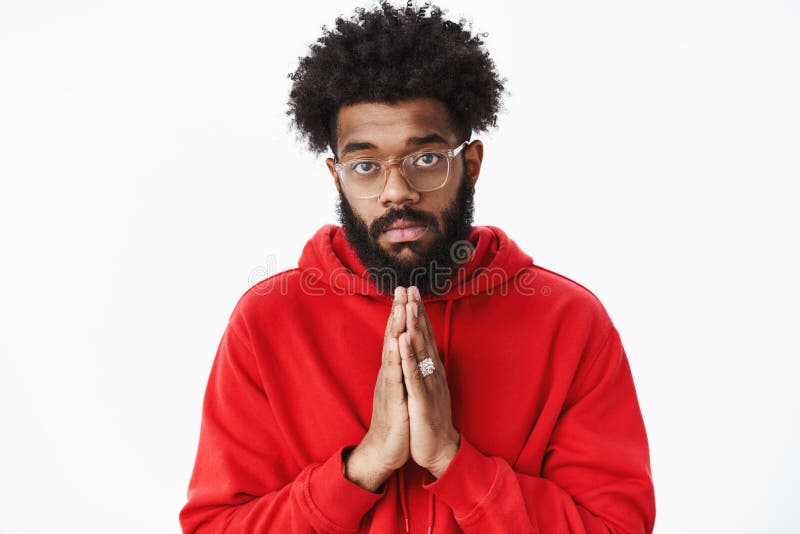 La taille- tirée du type africain à l'air sérieux avec la barbe tenant des mains prient dedans en tant que demander l'aide étant image stock La taille- tirée du type africain à l'air sérieux avec la barbe tenant des mains prient dedans en tant que demander l'aide étant image stock