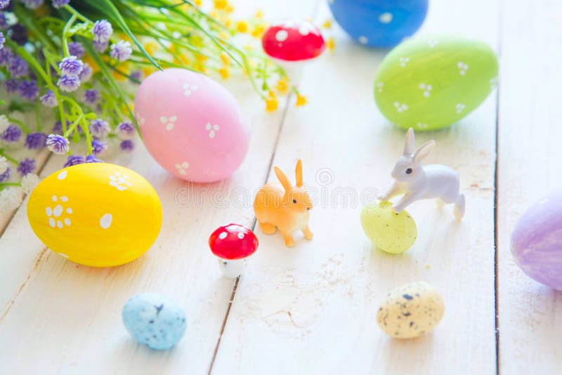 La tarjeta de felicitación de Pascua con las flores, conejito de los conejos de pascua juega y eggs en el tablón de madera blanco fotografía de archivo La tarjeta de felicitación de Pascua con las flores, conejito de los conejos de pascua juega y eggs en el tablón de madera blanco fotografía de archivo