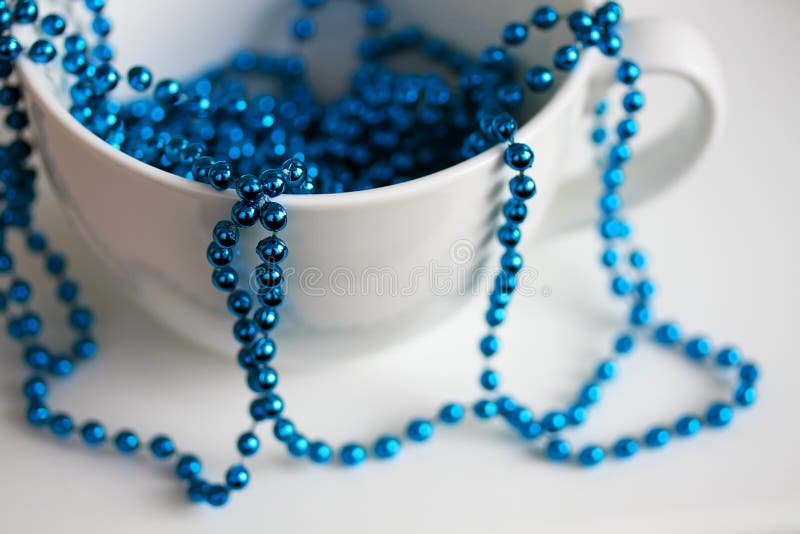 La tasse blanche avec les perles bleues image stock La tasse blanche avec les perles bleues image stock