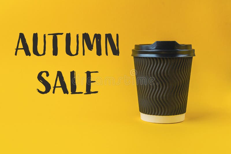 Tasse de café avec couvercle sur fond jaune avec les mots vente d'automne écrit en dessous. la tasse de café est le point central de l'image et l'arrière-plan jaune ajoute une brillance