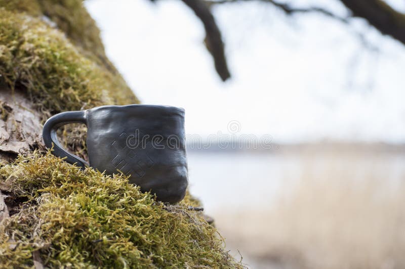 La tasse faite main unique avec des gens se connectent la mousse avec le lac brouillé sur le fond images libres de droits La tasse faite main unique avec des gens se connectent la mousse avec le lac brouillé sur le fond images libres de droits