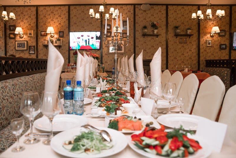 La tavola di banchetto nel ristorante è completamente riservata e gli spuntini sono su esposizione immagini stock libere da diritti La tavola di banchetto nel ristorante è completamente riservata e gli spuntini sono su esposizione immagini stock libere da diritti