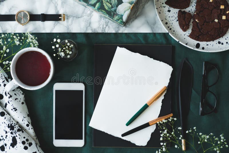La tavola di marmo del modello con la vista superiore di carta vuota con due penne di spoletta, i vetri, la tazza con tè ed il mo immagine stock libera da diritti La tavola di marmo del modello con la vista superiore di carta vuota con due penne di spoletta, i vetri, la tazza con tè ed il mo immagine stock libera da diritti