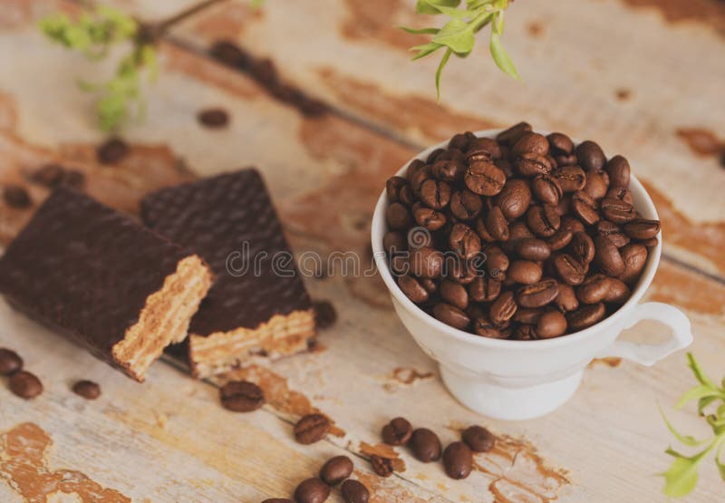 La taza de café con los granos dispersó en un fondo de madera galleta del chocolate, postre dulce imagenes de archivo La taza de café con los granos dispersó en un fondo de madera galleta del chocolate, postre dulce imagenes de archivo