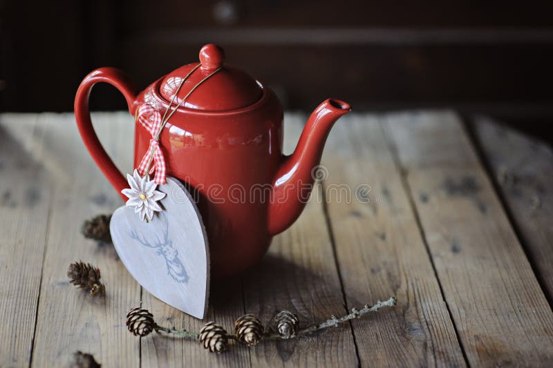 La teiera rossa, cuore di Natale ha modellato la decorazione e le pigne fotografie stock libere da diritti La teiera rossa, cuore di Natale ha modellato la decorazione e le pigne fotografie stock libere da diritti