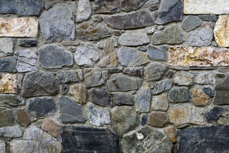 Texture, the background of the wall lined with natural stones of different shapes sizes and colors, Georgia. Texture, the background of the wall lined with natural stones of different shapes sizes and colors, Georgia